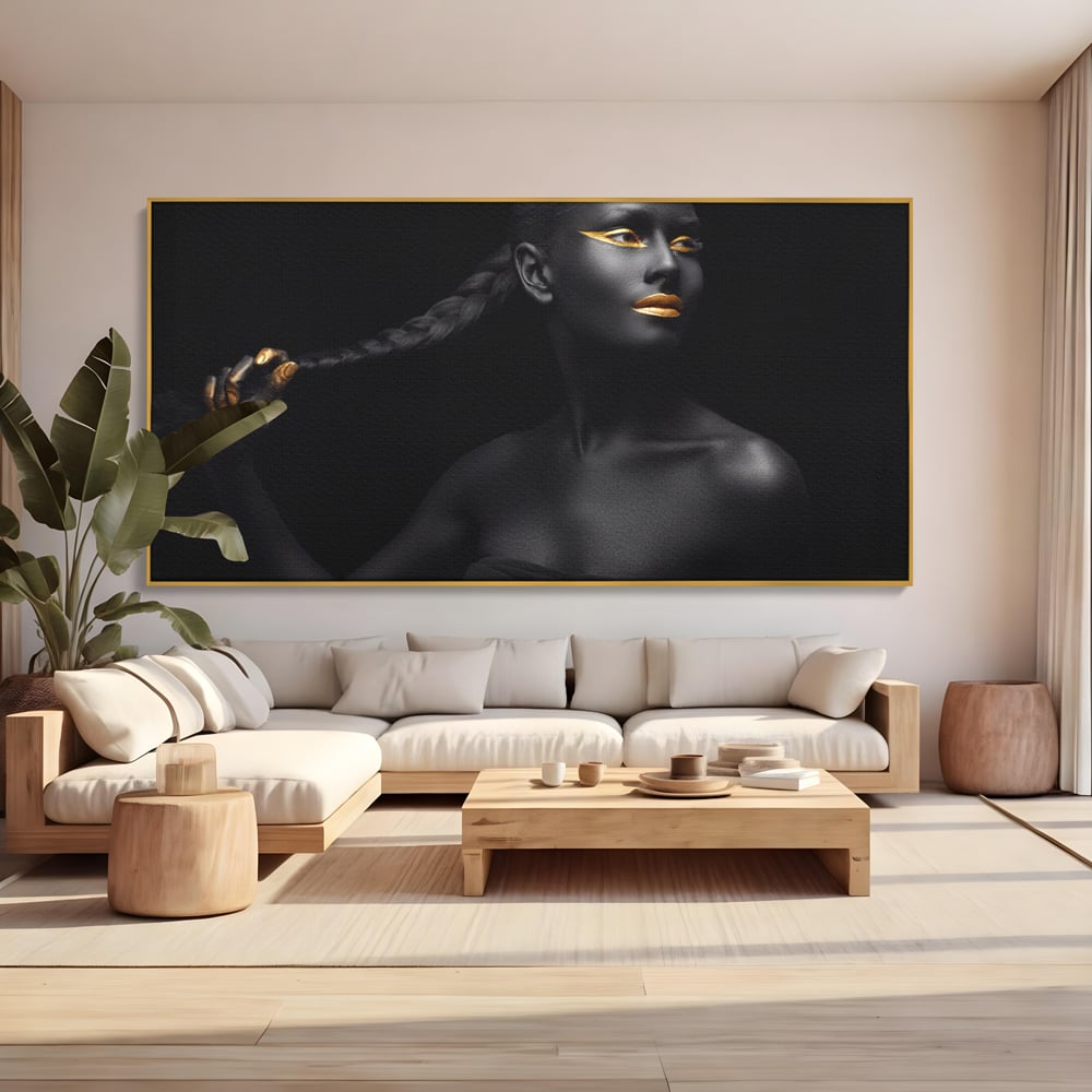 Tablou canvas cu tablou canvas cu femeie vopsita in negru si auriu, in rama de aluminiu auriu, pe perete intr-un living